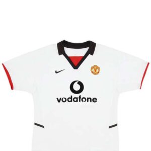Manchester United Away Retro Football Shirt 2002-03 – Soccerlords The Manchester United Away Retro Football Shirt 2002-03 is a timeless piece of football history that allows you to relive the glory days of one of the most iconic football clubs in the world. This meticulously crafted replica shirt captures the essence of Manchester United’s away kit from the 2002-03 season, a period that saw the club achieve remarkable success. Made with utmost attention to detail, this retro shirt features the a bright white and bold black design, adorned with the legendary Manchester United crest proudly displayed on the chest. The 2002-03 season was a remarkable one for Manchester United, as they clinched the Premier League title with an impressive 83 points. This shirt represents the triumphs and memories of that season, including memorable victories against fierce rivals and unforgettable moments on the pitch. By owning this retro football shirt, you become a part of Manchester United’s rich history and heritage. Whether you’re a die-hard fan who wants to display your allegiance or a collector seeking a valuable piece of football memorabilia, this shirt offers immense value. It serves as a tangible connection to the club’s glorious past, allowing you to reminisce about the players, matches, and triumphs that have shaped Manchester United’s legacy. Not only does this retro shirt offer a nostalgic journey through time, but it also provides a unique opportunity to stand out from the crowd. Crafted with premium materials, this Manchester United Away Retro Football Shirt 2002-03 ensures durability and longevity, allowing you to cherish it for years to come. It’s a must-have for any Manchester United supporter who wants to celebrate the club’s history and showcase their unwavering loyalty. In summary, the Manchester United Away Retro Football Shirt 2002-03 is more than just a piece of clothing. It’s a symbol of pride, a connection to the club’s glorious past, and a way to express your love for Manchester United. Own a piece of football history and relive the triumphs of one of the greatest football clubs in the world.