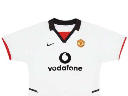 Manchester United Away Retro Football Shirt 2002-03 – Soccerlords The Manchester United Away Retro Football Shirt 2002-03 is a timeless piece of football history that allows you to relive the glory days of one of the most iconic football clubs in the world. This meticulously crafted replica shirt captures the essence of Manchester United’s away kit from the 2002-03 season, a period that saw the club achieve remarkable success. Made with utmost attention to detail, this retro shirt features the a bright white and bold black design, adorned with the legendary Manchester United crest proudly displayed on the chest. The 2002-03 season was a remarkable one for Manchester United, as they clinched the Premier League title with an impressive 83 points. This shirt represents the triumphs and memories of that season, including memorable victories against fierce rivals and unforgettable moments on the pitch. By owning this retro football shirt, you become a part of Manchester United’s rich history and heritage. Whether you’re a die-hard fan who wants to display your allegiance or a collector seeking a valuable piece of football memorabilia, this shirt offers immense value. It serves as a tangible connection to the club’s glorious past, allowing you to reminisce about the players, matches, and triumphs that have shaped Manchester United’s legacy. Not only does this retro shirt offer a nostalgic journey through time, but it also provides a unique opportunity to stand out from the crowd. Crafted with premium materials, this Manchester United Away Retro Football Shirt 2002-03 ensures durability and longevity, allowing you to cherish it for years to come. It’s a must-have for any Manchester United supporter who wants to celebrate the club’s history and showcase their unwavering loyalty. In summary, the Manchester United Away Retro Football Shirt 2002-03 is more than just a piece of clothing. It’s a symbol of pride, a connection to the club’s glorious past, and a way to express your love for Manchester United. Own a piece of football history and relive the triumphs of one of the greatest football clubs in the world.