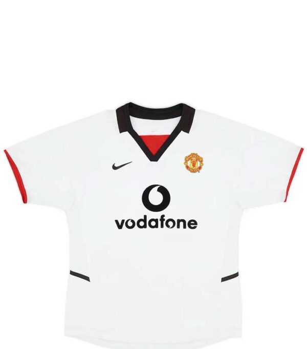 Manchester United Away Retro Football Shirt 2002-03 – Soccerlords The Manchester United Away Retro Football Shirt 2002-03 is a timeless piece of football history that allows you to relive the glory days of one of the most iconic football clubs in the world. This meticulously crafted replica shirt captures the essence of Manchester United’s away kit from the 2002-03 season, a period that saw the club achieve remarkable success. Made with utmost attention to detail, this retro shirt features the a bright white and bold black design, adorned with the legendary Manchester United crest proudly displayed on the chest. The 2002-03 season was a remarkable one for Manchester United, as they clinched the Premier League title with an impressive 83 points. This shirt represents the triumphs and memories of that season, including memorable victories against fierce rivals and unforgettable moments on the pitch. By owning this retro football shirt, you become a part of Manchester United’s rich history and heritage. Whether you’re a die-hard fan who wants to display your allegiance or a collector seeking a valuable piece of football memorabilia, this shirt offers immense value. It serves as a tangible connection to the club’s glorious past, allowing you to reminisce about the players, matches, and triumphs that have shaped Manchester United’s legacy. Not only does this retro shirt offer a nostalgic journey through time, but it also provides a unique opportunity to stand out from the crowd. Crafted with premium materials, this Manchester United Away Retro Football Shirt 2002-03 ensures durability and longevity, allowing you to cherish it for years to come. It’s a must-have for any Manchester United supporter who wants to celebrate the club’s history and showcase their unwavering loyalty. In summary, the Manchester United Away Retro Football Shirt 2002-03 is more than just a piece of clothing. It’s a symbol of pride, a connection to the club’s glorious past, and a way to express your love for Manchester United. Own a piece of football history and relive the triumphs of one of the greatest football clubs in the world.